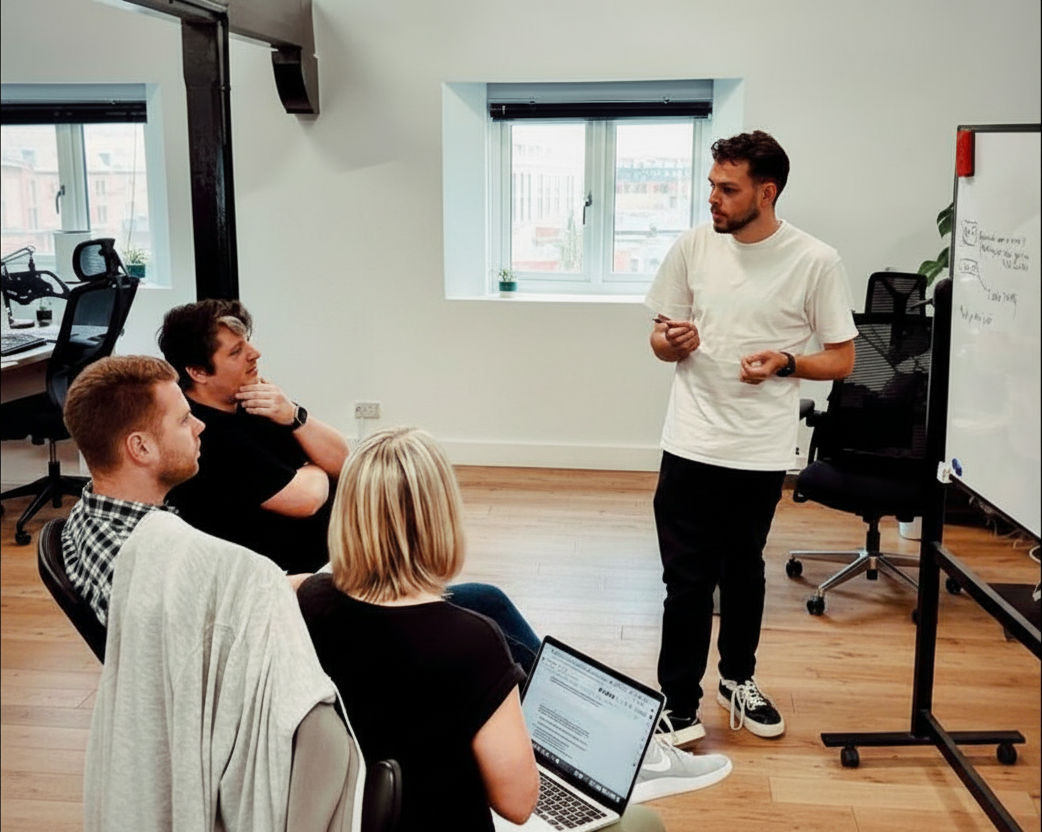 The Rofinery team talking through work at a desk